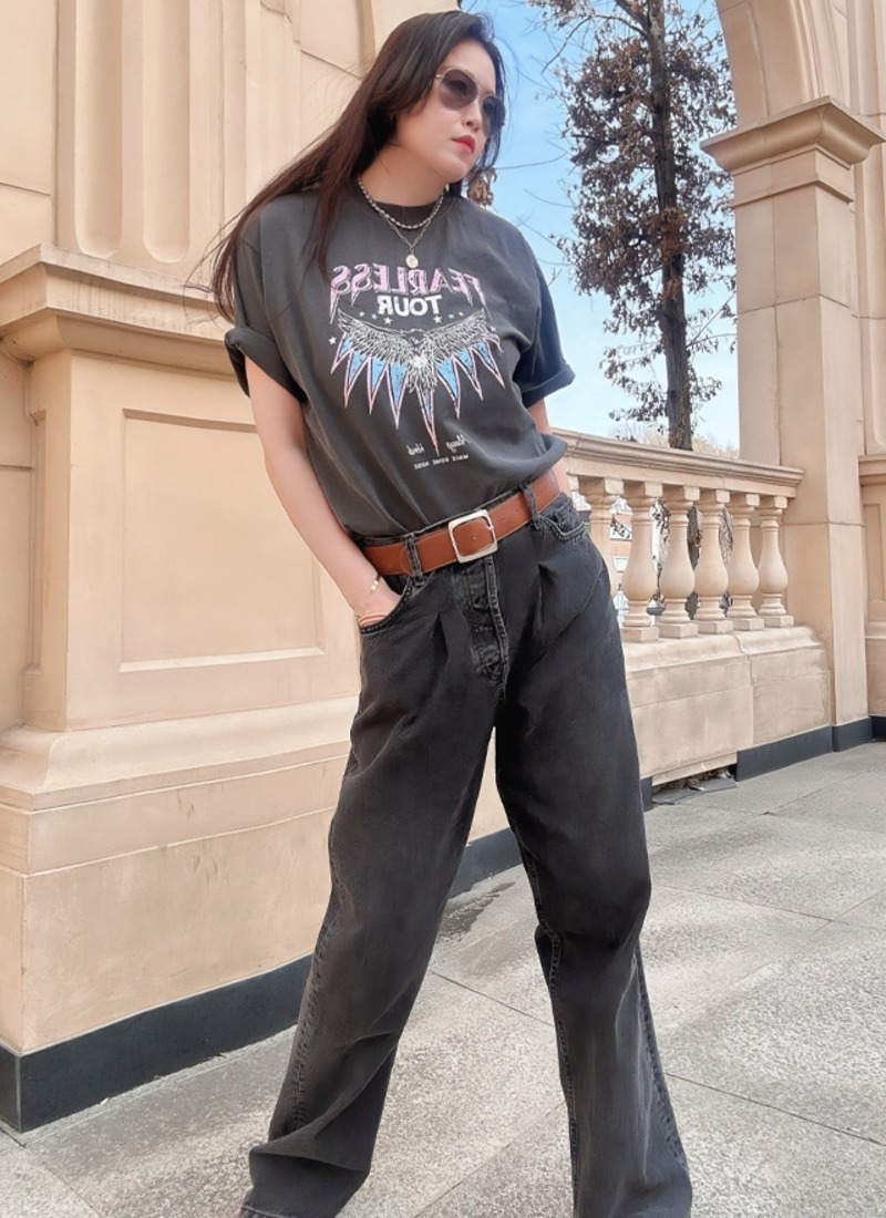 Washed graphic T-shirt ending above loose black jeans with a brown belt